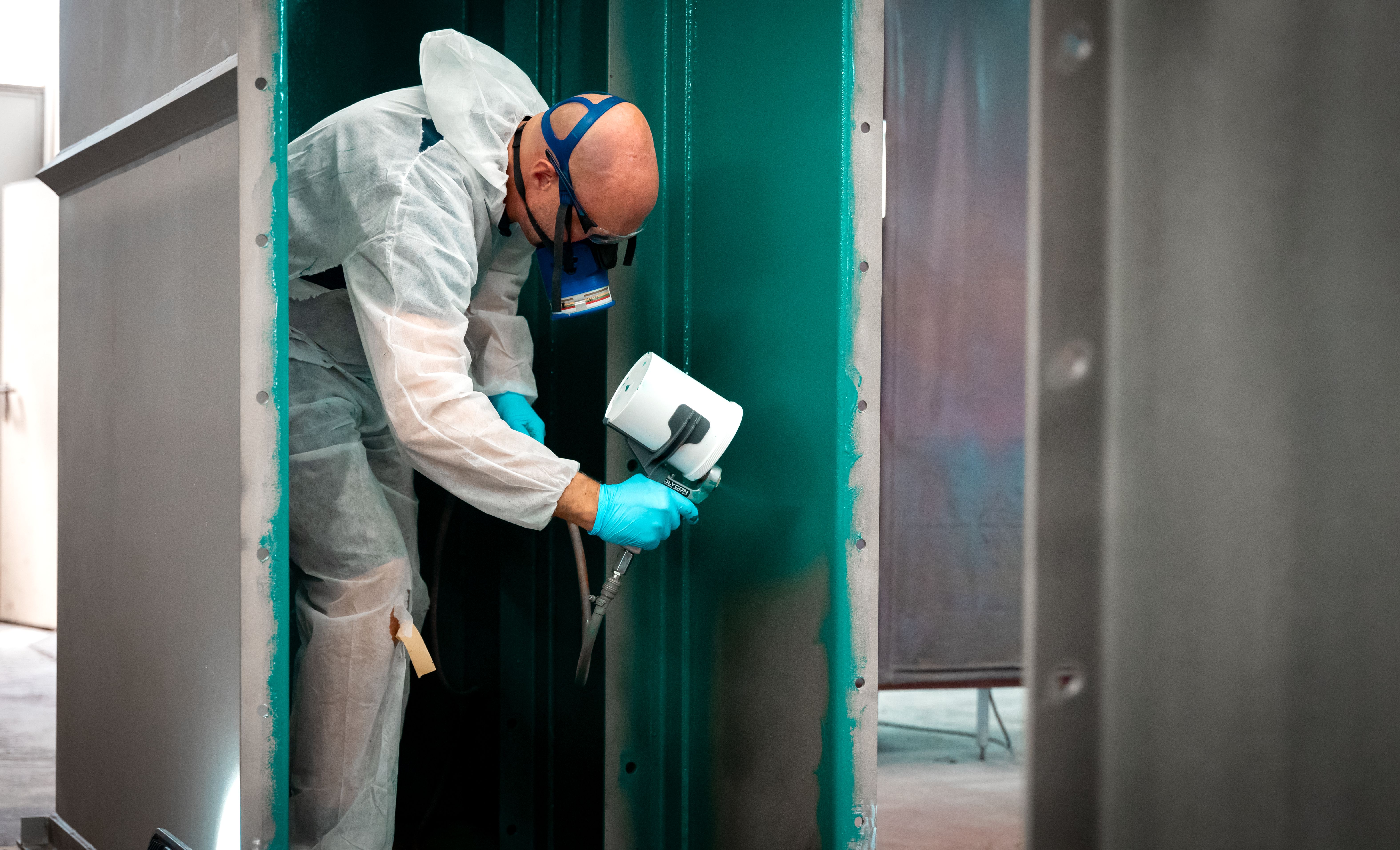 Un homme portant un masque pulvérise une couche de contrôle verte